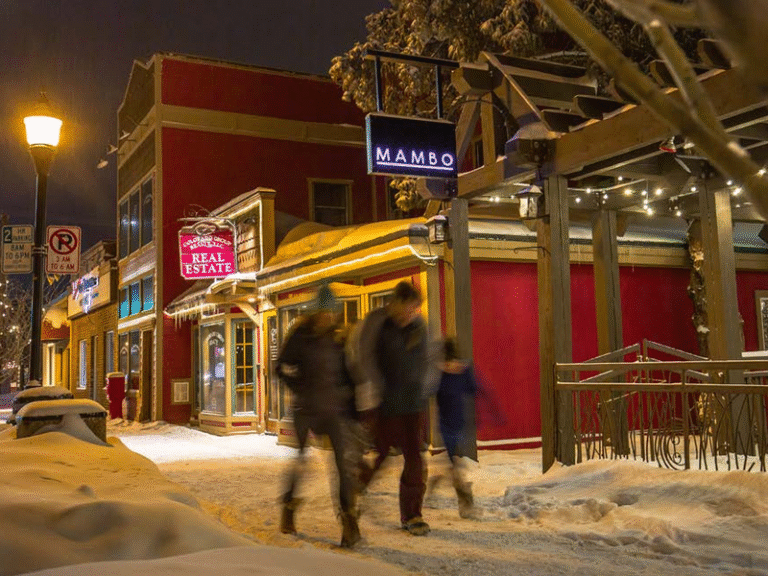 Illuminated snowy street scene in the cozy ambiance of Steamboat Springs at night.