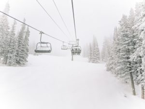 A gondola going up a snowy mountainside