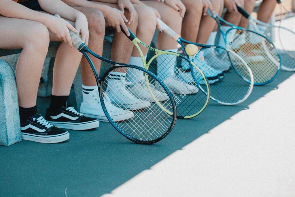 A line of tennis players' sneakers and rackets