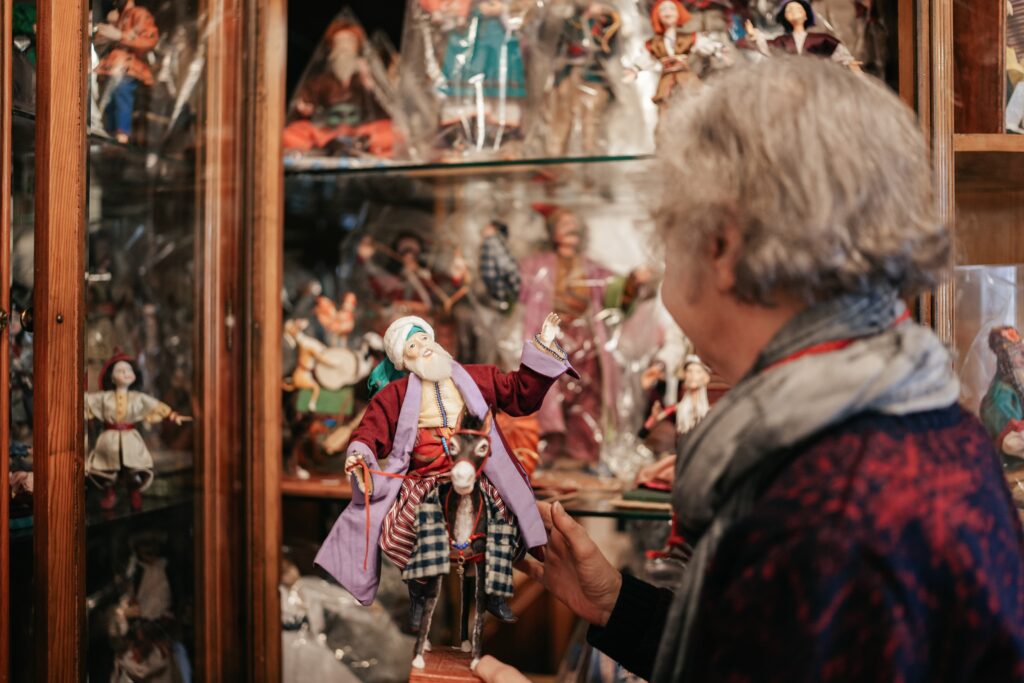 A woman picks up a doll in a toyshop