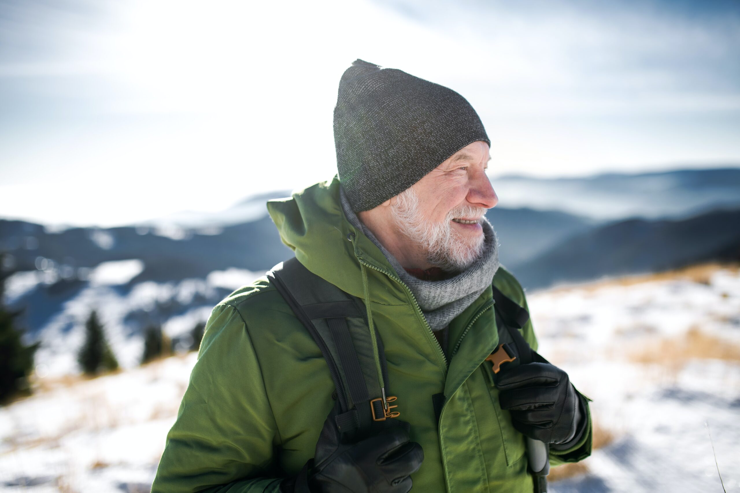 A man looks out at a snowy mountain peak