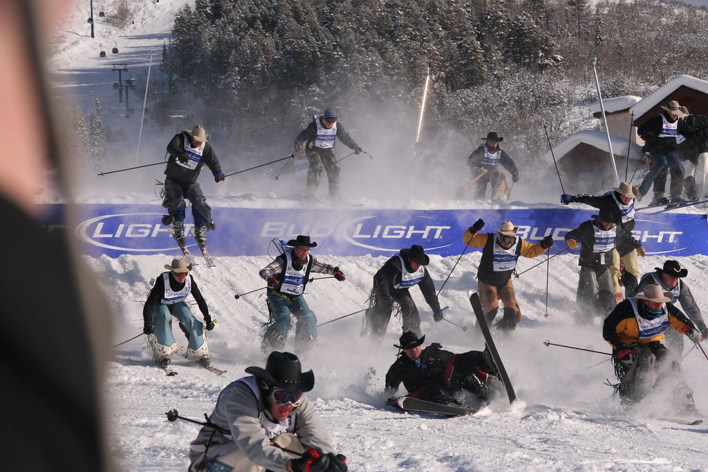 A group of cowboys fly over a large ski jump