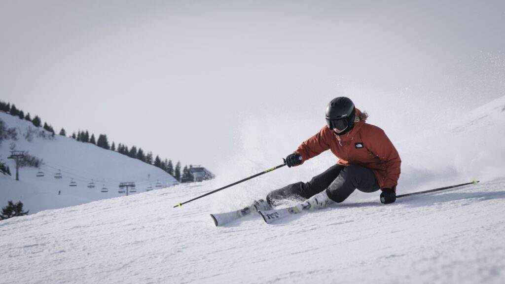 A skier zooms down a snowy slope
