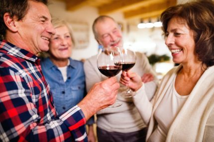 Four friends clink wine glasses