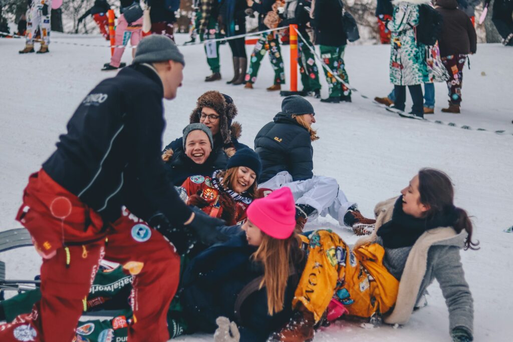 A group of friends laugh on the snow covered floor