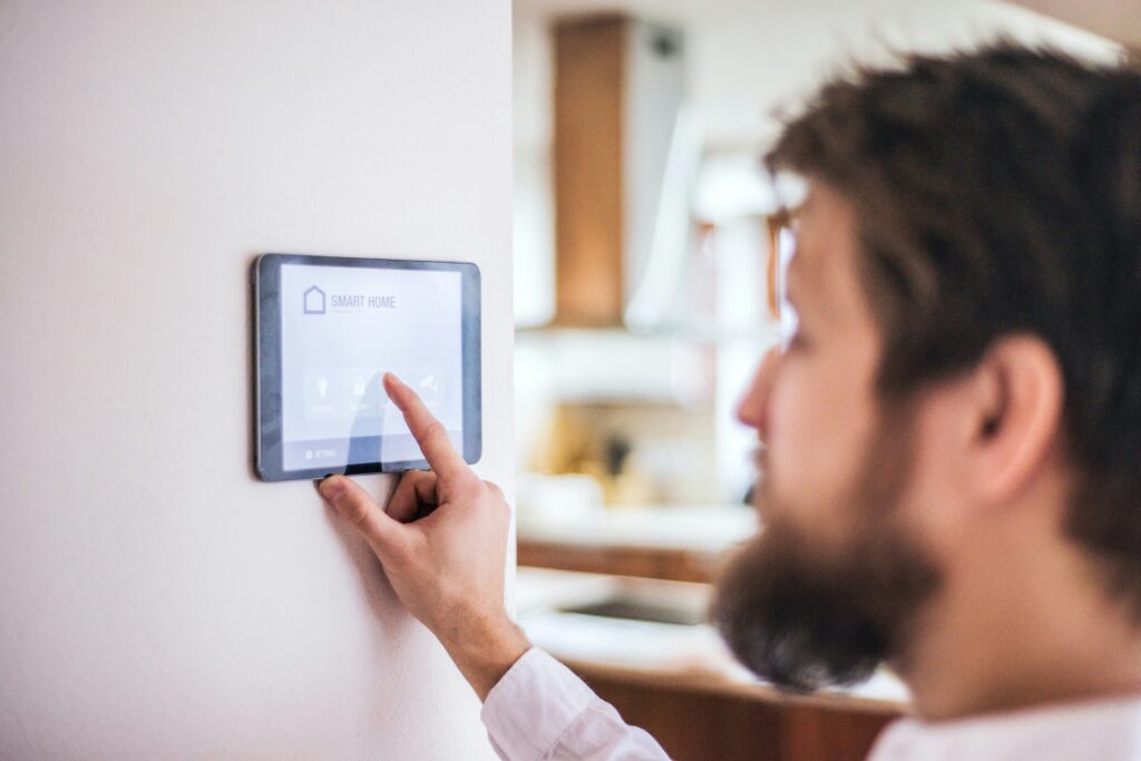 A man taps his home security panel
