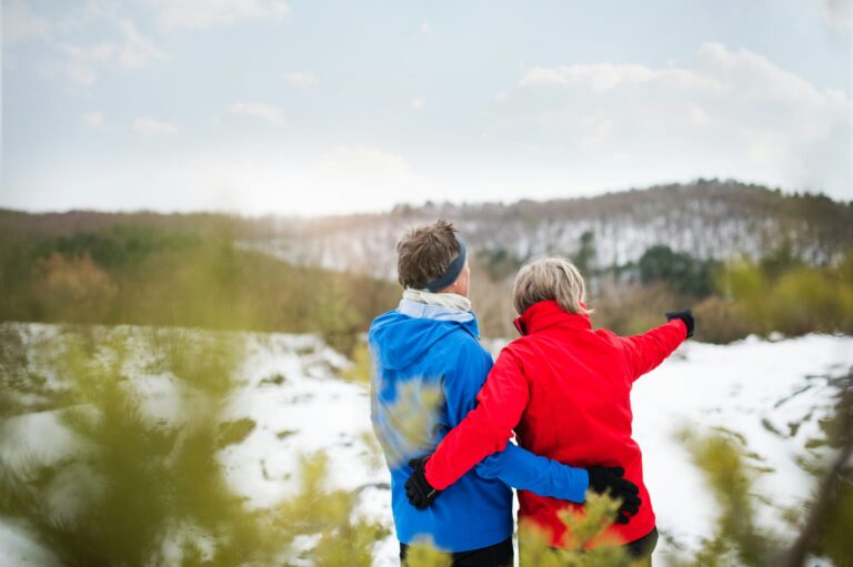 A couple embrace, looking out at a snowy landscape