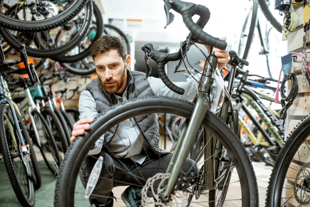 A man examines a bike in a sports shop