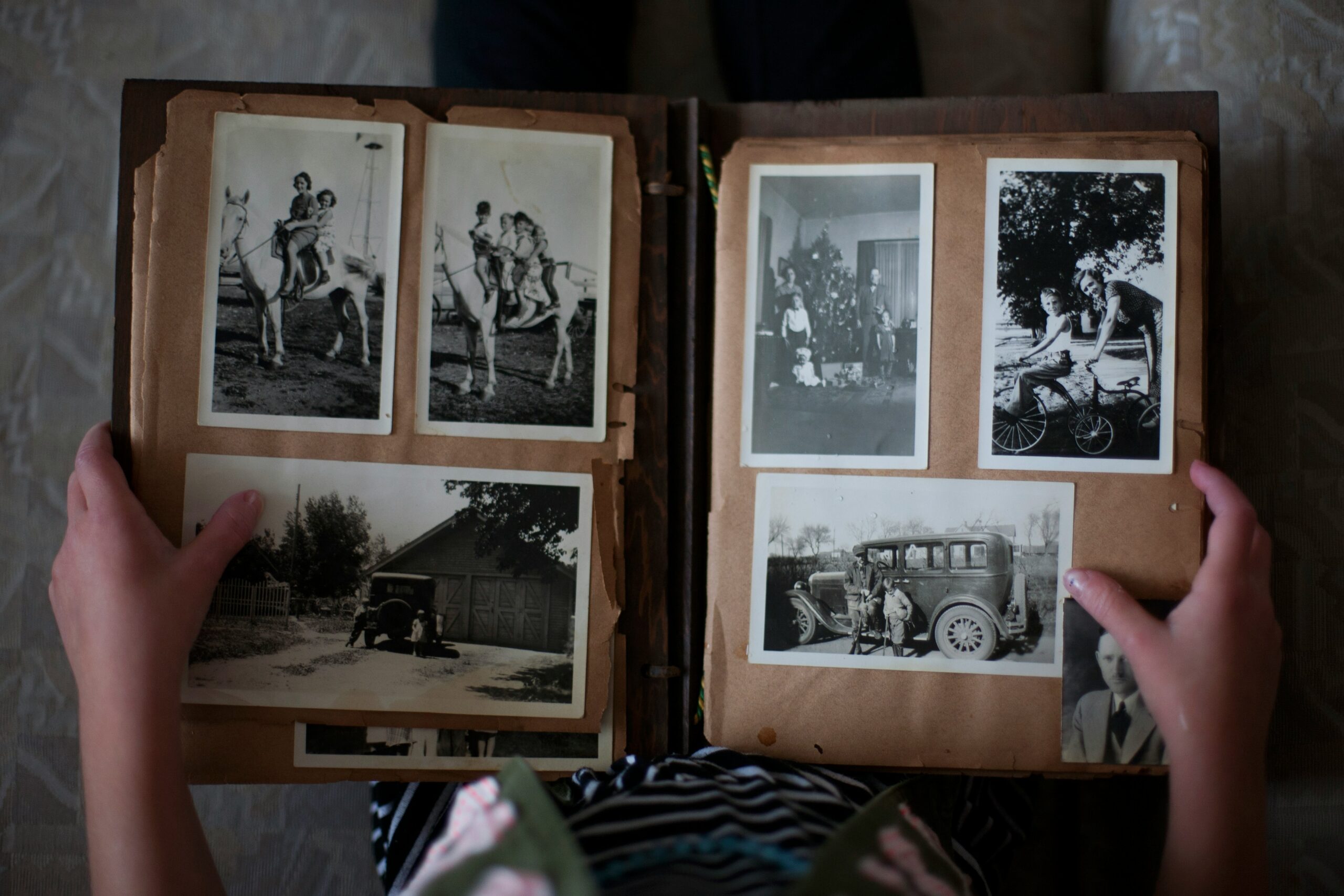 Two hands holding a book of black and white photographs