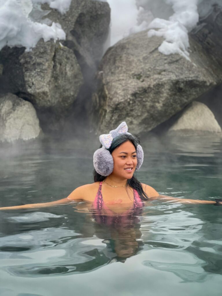 A woman wearing ear muffs in a hot spring