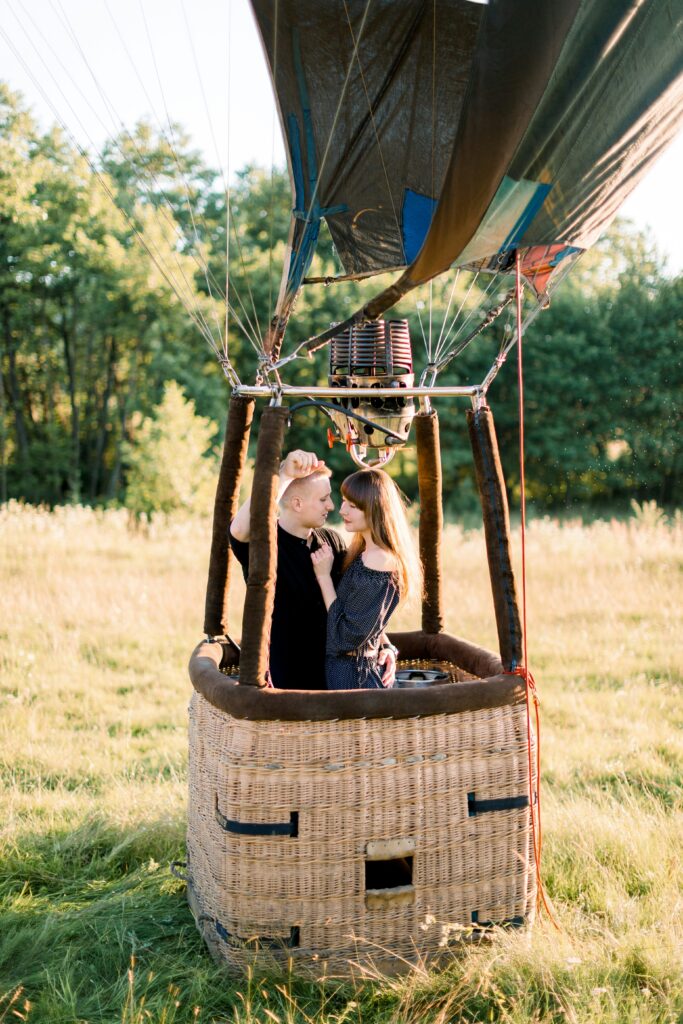 A couple hug inside a hot air balloon basket