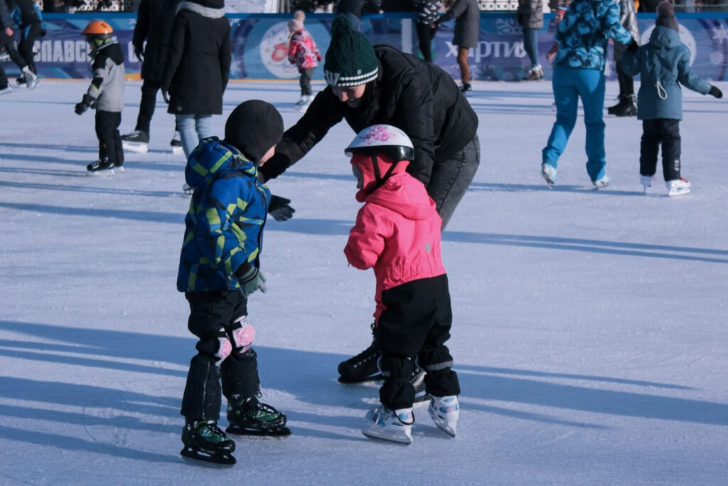A mother and two children ice skating