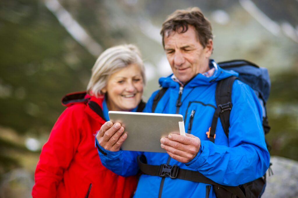 A couple hiking, using a tablet to assist them