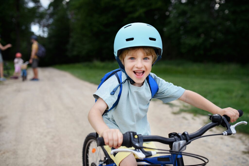 A little boy smiles riding a bike