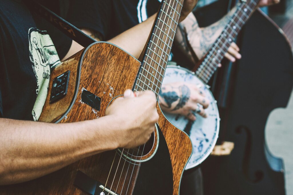 Two people playing a guitar and a banjo