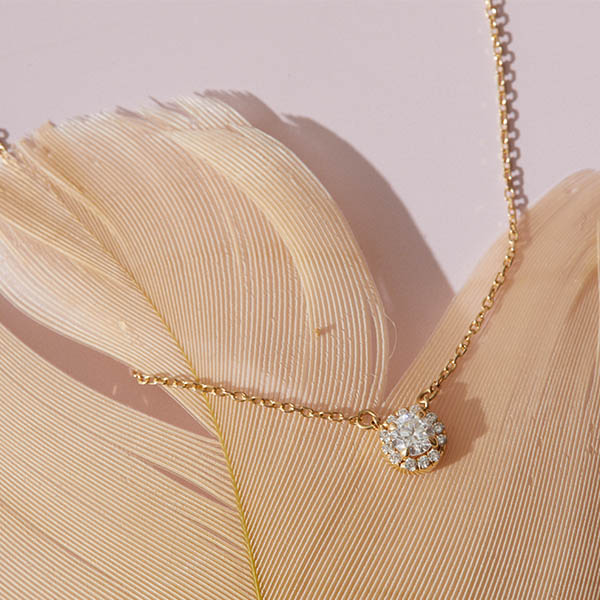 A diamond necklace resting on a feather