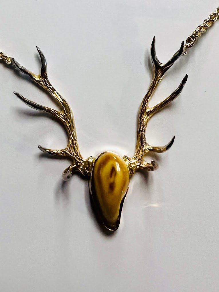 An elk ivory broach with gold antlers