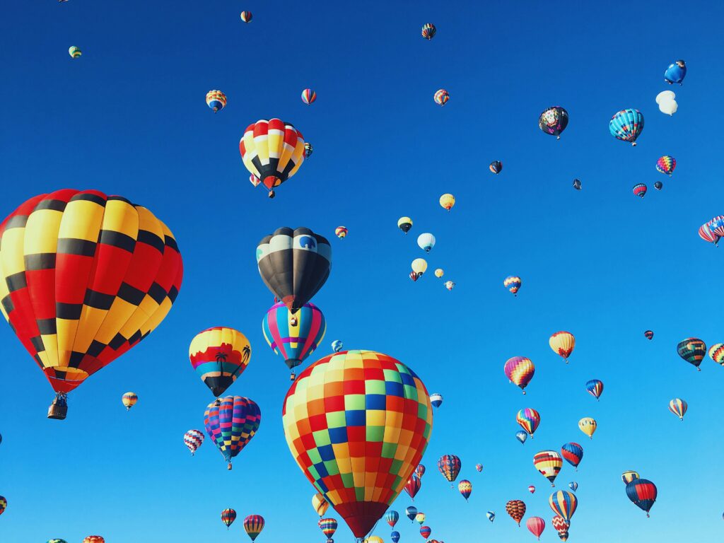 A display of hot air balloons in a blue sky