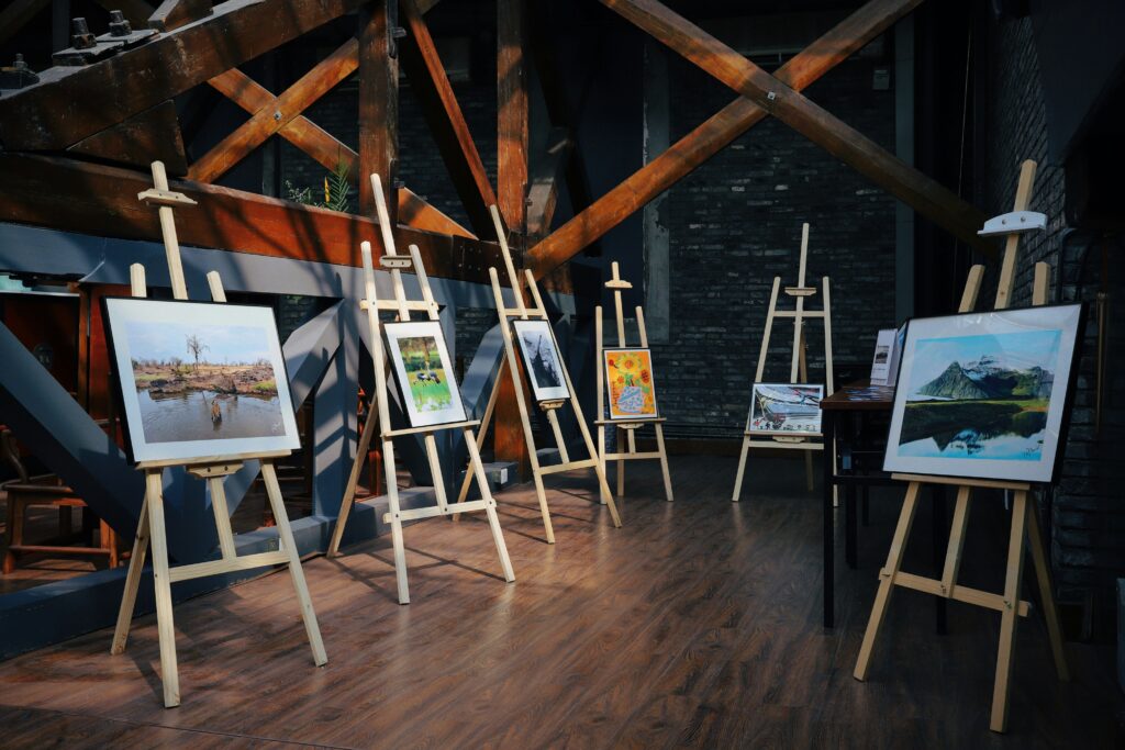 Six paintings displayed on easels 