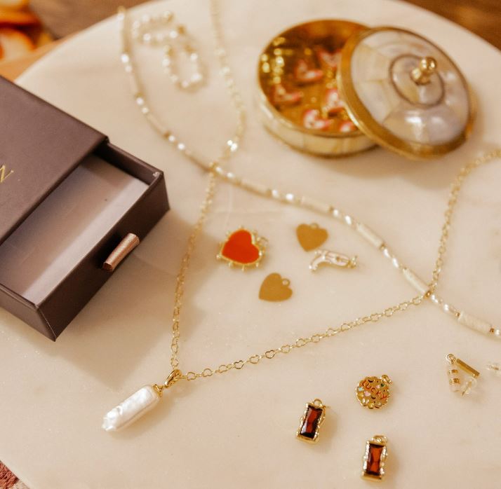 An assortment of gold jewelry on a white table