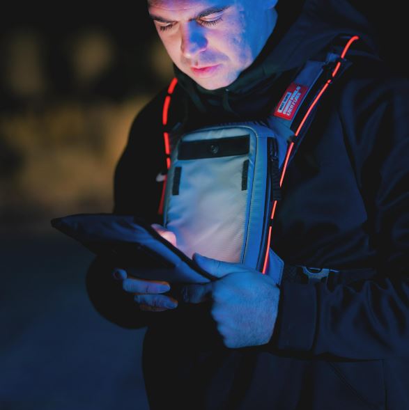 A man wearing a West Slope Chest Pack at night
