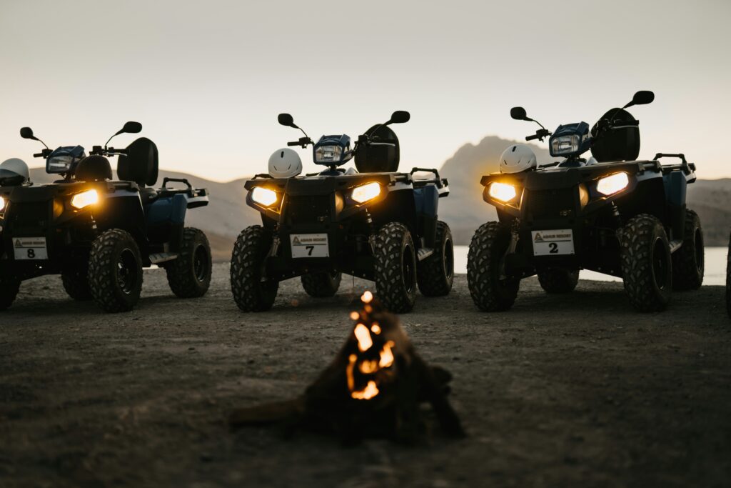 Three ATVs next to a campfire