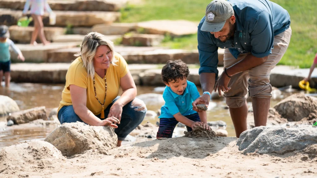 A family playing in sand at Burgess Creek