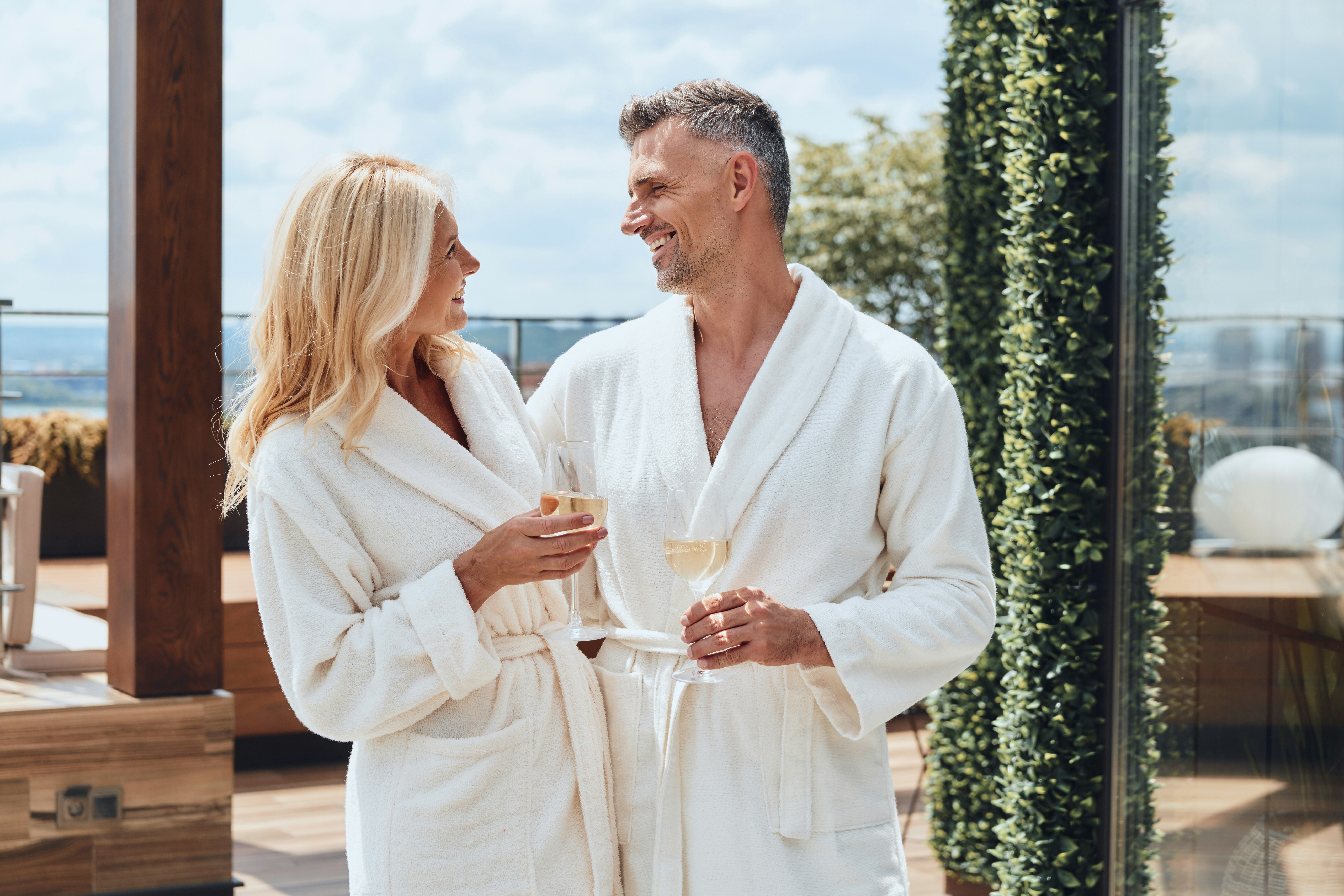 A couple in white bath robes toasting to their new vacation home