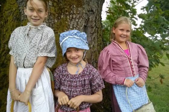 Three children dressed in pioneer clothing