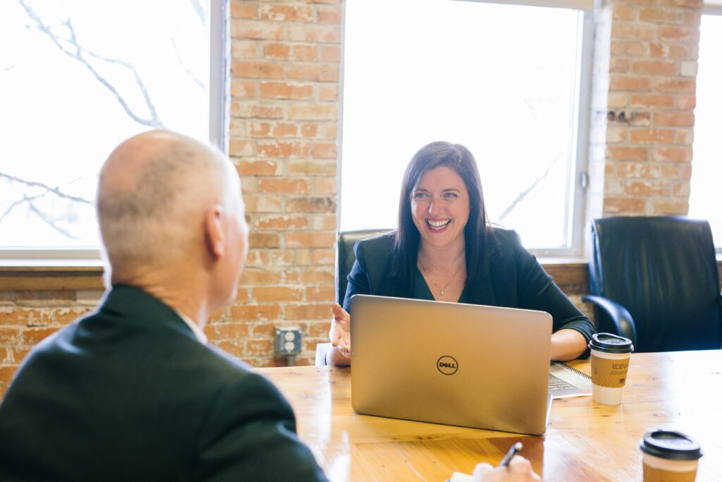 Two smartly dressed people smiling and discussing