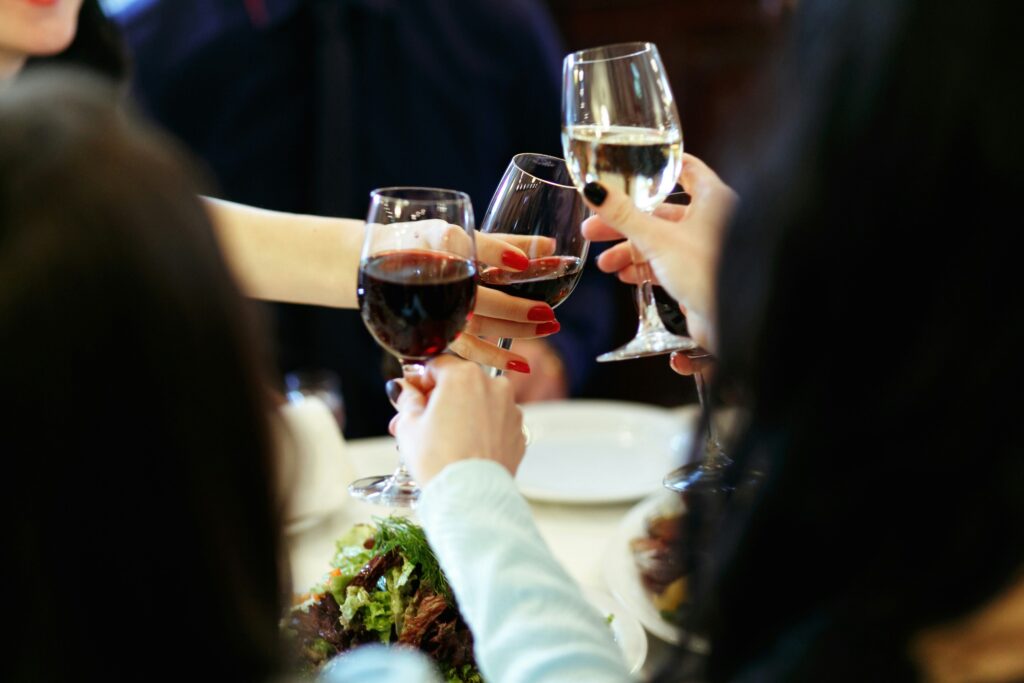 Women clinking wine glasses at dinner