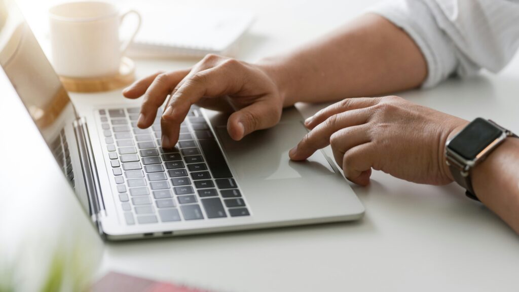 A person's hands on a laptop