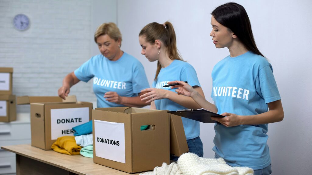 Three volunteers loading donation boxes