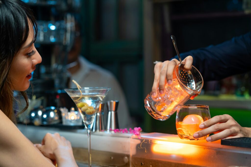 A woman watching a cocktail being made