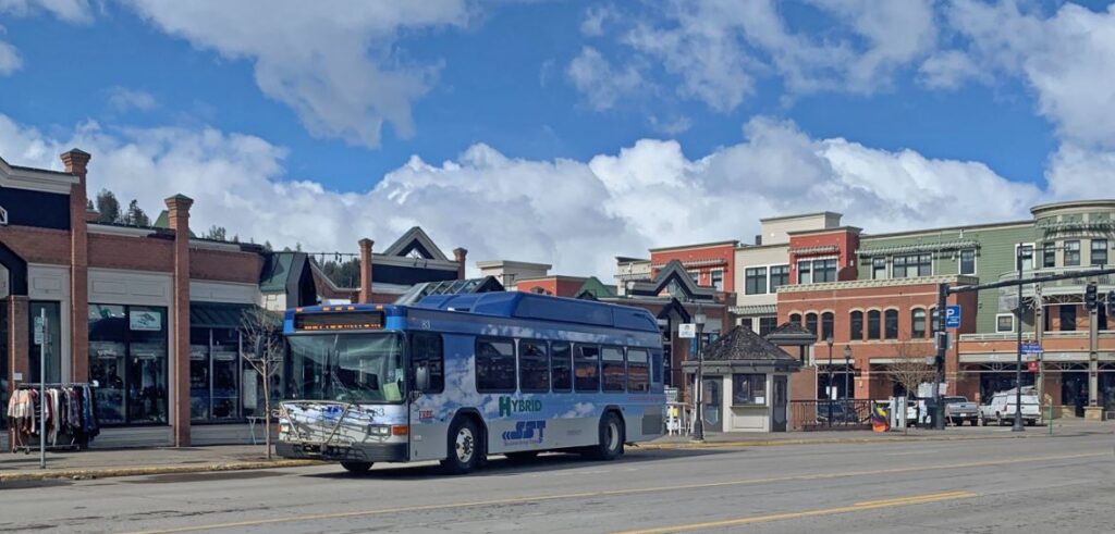 A blue bus driving through Steamboat Springs