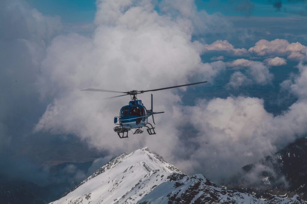 Helicopter flying over a snowcapped mountain. Best view of the fall leaves in Steamboat Springs