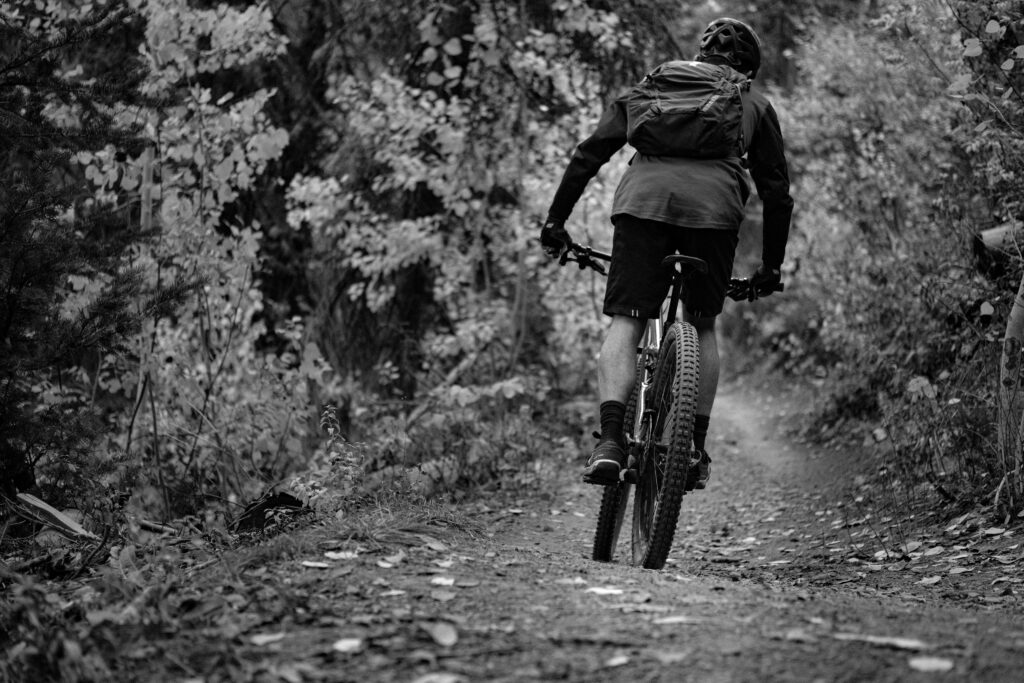 Black and white image of a solo biker on a trail for mountain biking in Steamboat Springs