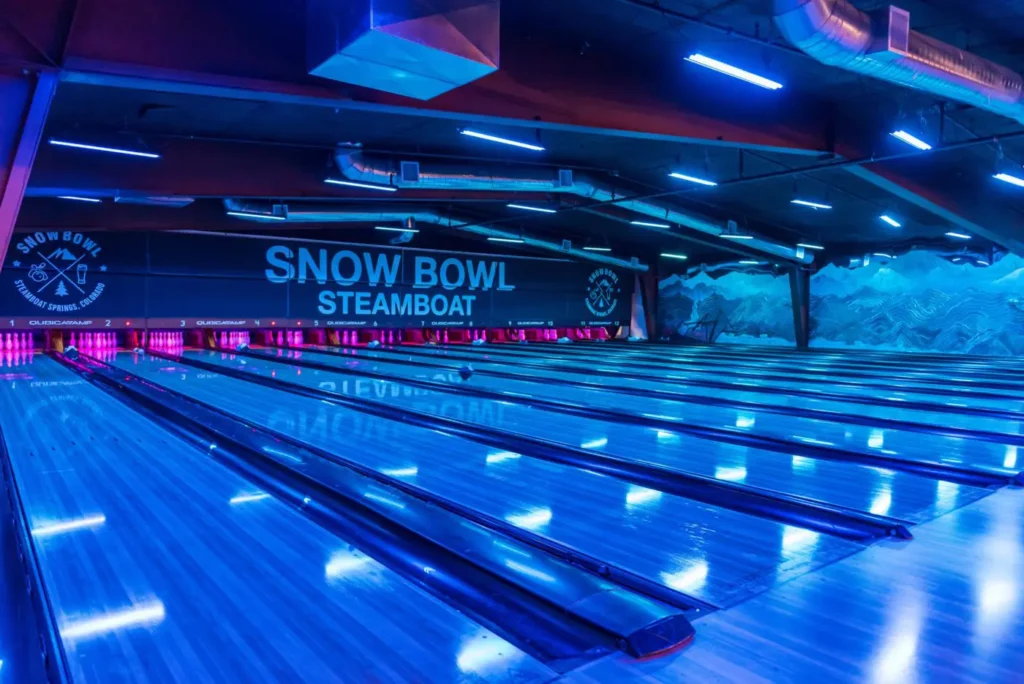 The bowling lanes at Snow Bowl lit up in a blue neon light. 