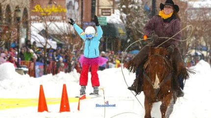 Child on skis being pulled by a woman on horseback