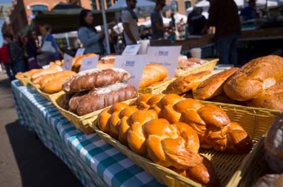 A long view of a table selling various types of bread and rolls.