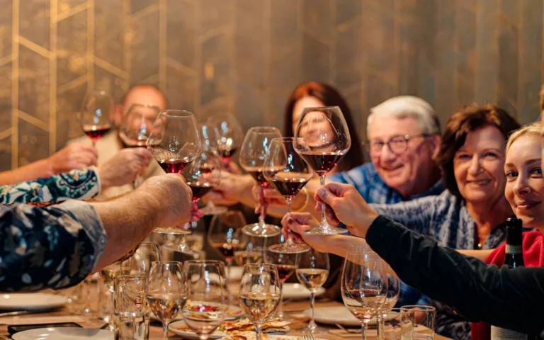Group of adults holding wine glasses and participating in a cheers