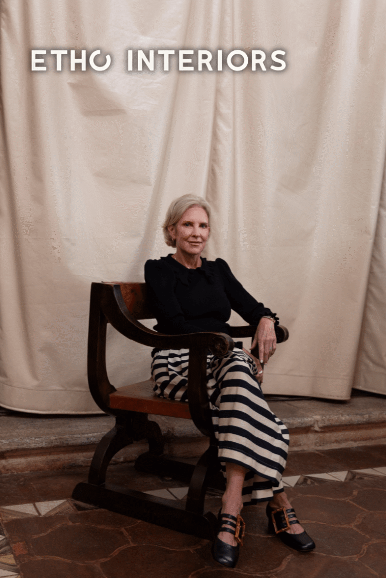 Portrait of Terrell Sherman, Interior & Exterior Designer at Etho Interiors, seated on a wooden chair against a draped backdrop.