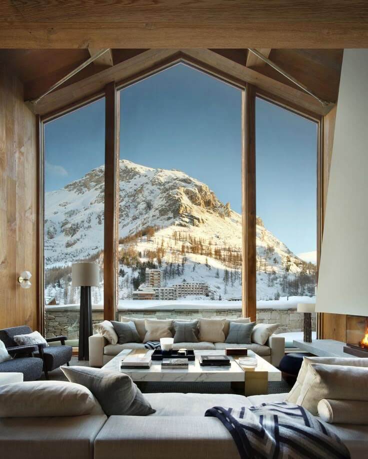 Panoramic mountain view seen through floor-to-ceiling windows inside a warm, modern living space at The Astrid.