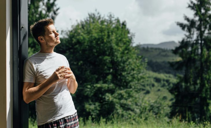 A man relaxing by a window with a coffee