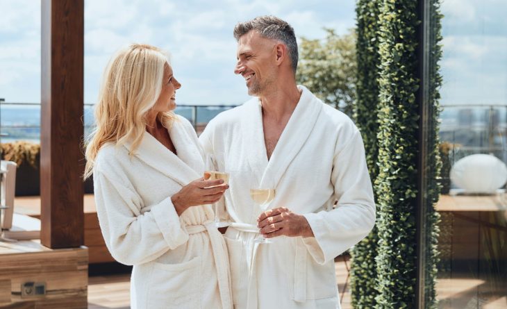A couple in white bath robes toasting to their new vacation home
